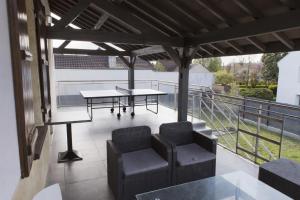 a patio with two tables and chairs on a balcony at Square'71 - T4 Duplex avec terrasse - espace détente in Chalon-sur-Saône