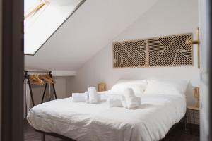 a bedroom with a white bed with towels on it at Square'71 - T4 Duplex avec terrasse - espace détente in Chalon-sur-Saône