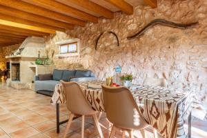 a dining room with a stone wall with a table and chairs at Finca Agroturismo Sa Cova den Borino in Campos +109 photos