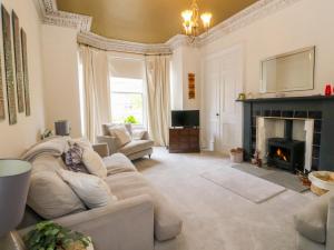 a living room with a couch and a fireplace at Rowan Tree House in Brechin
