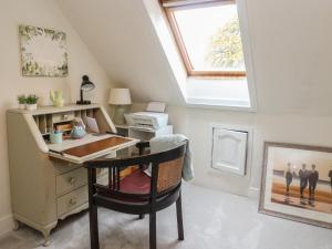 an attic office with a desk and a window at Rowan Tree House in Brechin