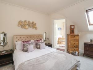 a bedroom with a large white bed with pillows at Rowan Tree House in Brechin