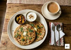 a plate with two pizzas on a table with a cup of coffee at Hotel Meerut International in Meerut