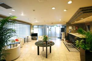 a large lobby with plants and a table in a room at Urban Hotel Twins Chofu in Chofu