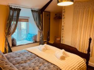 a bedroom with a large bed with towels on it at The Hideaway in Tintagel