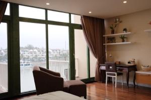a bedroom with a desk and a large window at Lam Home Tuần Châu in Ha Long
