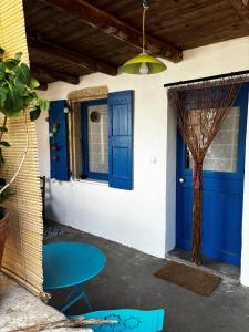 a blue door and a table in front of a house at Longo maï in Vallon-Pont-dʼArc