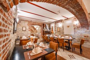a restaurant with tables and chairs and a brick wall at Hotel Varazdin in Varaždin