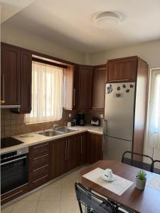 a kitchen with wooden cabinets and a white refrigerator at Relaxivng home 2 in Konístrai