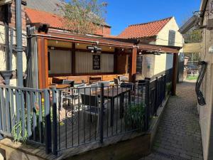 an outdoor patio with a fence and tables and chairs at The Royal Oak Ripon in Ripon