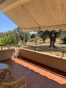 a balcony with a table and chairs and a view of a field at Relaxivng home 2 in Konístrai
