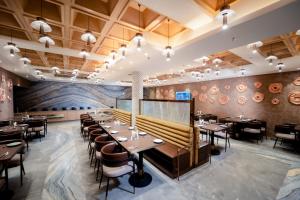 a dining room with tables and chairs and a mural at The Panache Kautilya in Patna