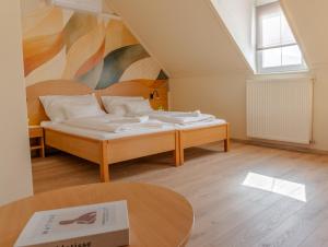 a bedroom with a bed with a painting on the wall at Levendula Resort és Rendezvényközpont in Bogács