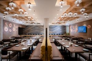 a dining room with long tables and chairs at The Panache Kautilya in Patna