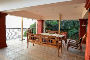 a room with a balcony with a table and chairs at Serenity by the Sea Goa in Silidao
