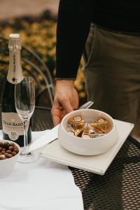 a person holding a bowl of food next to a bottle of wine at Landgoed Oud Poelgeest - Leiden in Oegstgeest