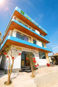 a building with two trees in front of it at Đức Loan Hotel Vĩnh Hy in Ninh Hải