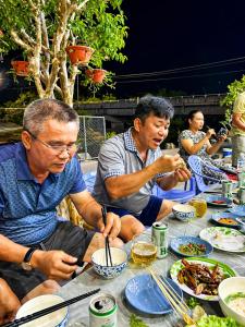 a group of people sitting at a table eating food at Đức Loan Hotel Vĩnh Hy in Ninh Hải