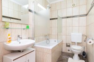 a bathroom with a sink and a toilet and a tub at Apartments Baltazar with Sea View&Jacuzzi in Dubrovnik +26 photos
