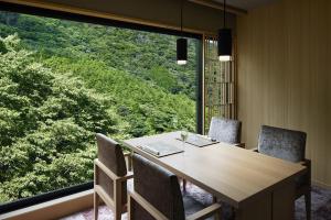 a dining room with a table and chairs and a large window at Hatsuhana in Hakone