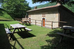 a group of picnic tables in front of a building at Locanda Le Isole in Poggio al Pozzo