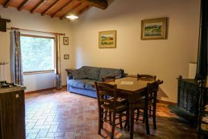 a living room with a table and a couch at Locanda Le Isole in Poggio al Pozzo