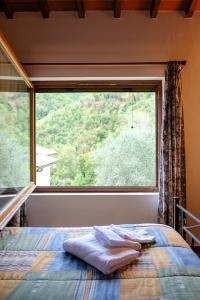 a bed in a room with a large window at Locanda Le Isole in Poggio al Pozzo