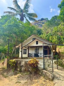 a small house with a palm tree in the background at Wind Bells in Anaviratty