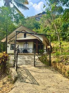 a small house with a gate in front of it at Wind Bells in Anaviratty