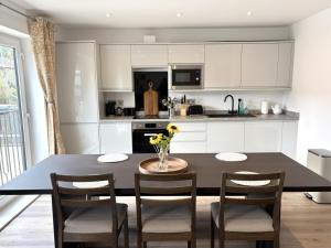 a kitchen with a table with chairs and a kitchen with white cabinets at Smithy Mills in Halifax