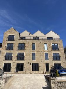 a large brick building with a car parked in front of it at Smithy Mills in Halifax