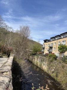 a river in front of a building and a riverurrency with a street at Smithy Mills in Halifax +12 photos