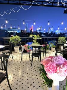 a patio with tables and chairs and flowers at night at Danang's house in Danang