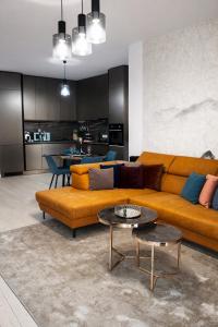 a living room with a couch and a table at Herastrau Prestige Apartment WIN in Bucharest