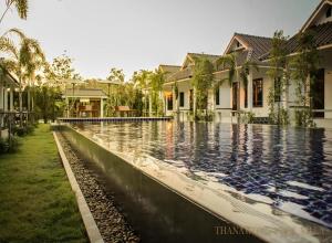a swimming pool in front of a house at Thanawong Pool Villa in Sukhothai +23 photos