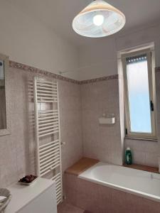a bathroom with a tub and a window and a bath tub at La Puteca di Nonna Cia in Andrano