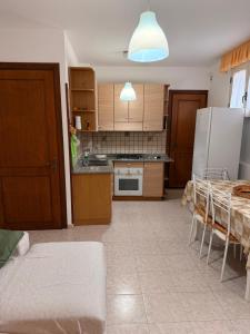 a kitchen with a table and a kitchen with a refrigerator at La Puteca di Nonna Cia in Andrano