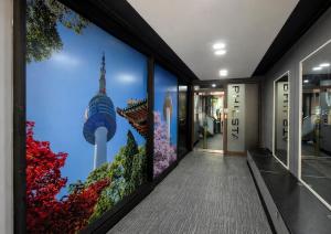 a hallway with a wall mural of a building at Philstay Myeongdong Boutique Female in Seoul