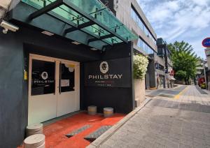a building on a street with the entrance to a pharmacy at Philstay Myeongdong Boutique Female in Seoul