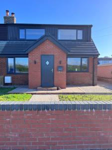 a brick house with a black door on a brick wall at Newly renovated countryside retreat in Scorton in Scorton