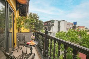 a balcony with a table and chairs on a balcony at Solar Premium Hotel & Spa in Hanoi