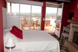 a bedroom with a white bed and a large window at La Media Luna in Segorbe
