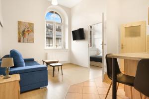 a living room with a blue couch and a window at Apartament Pierwszy Maj in Kudowa-Zdrój