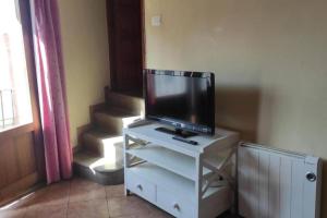 a tv on a white stand with a tv on it at La Media Luna in Segorbe