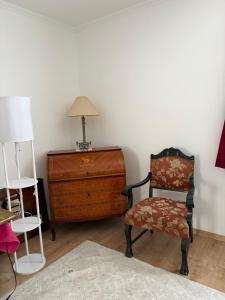 a room with a chair and a dresser and a lamp at Haus Erika in Gamlitz