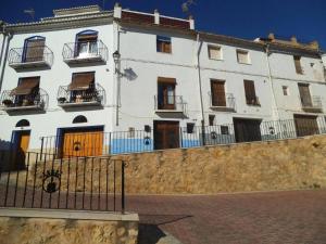 a white building with balconies and a fence at La Media Luna in Segorbe