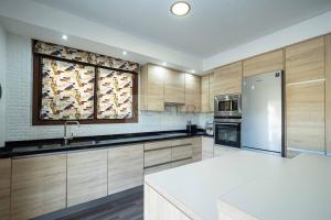 a large kitchen with wooden cabinets and a refrigerator at Pomar By Silastur in Obaya