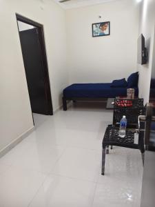 a living room with a blue couch and a table at Du Auro Residency in Kuilapayam