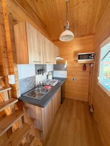 a kitchen with a sink in a wooden cabin at Kotwicownia in Mikołajki