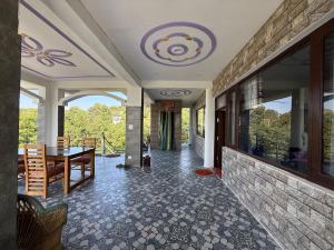 a living room with a table and a stone wall at Adhikari mountain view homestay in Chaubattia